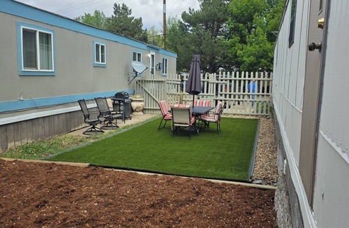 Longmont House | Relaxing home with landscaped back yard . Table and chairs outdoors.