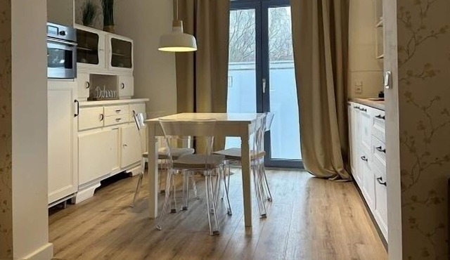 Bright apartment with a small, functional kitchen and a spacious dining area.