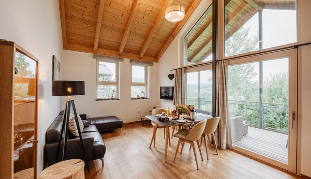 Ferienchalet mit überdachter Veranda mit Lounge Möbel und Schwebeliege.